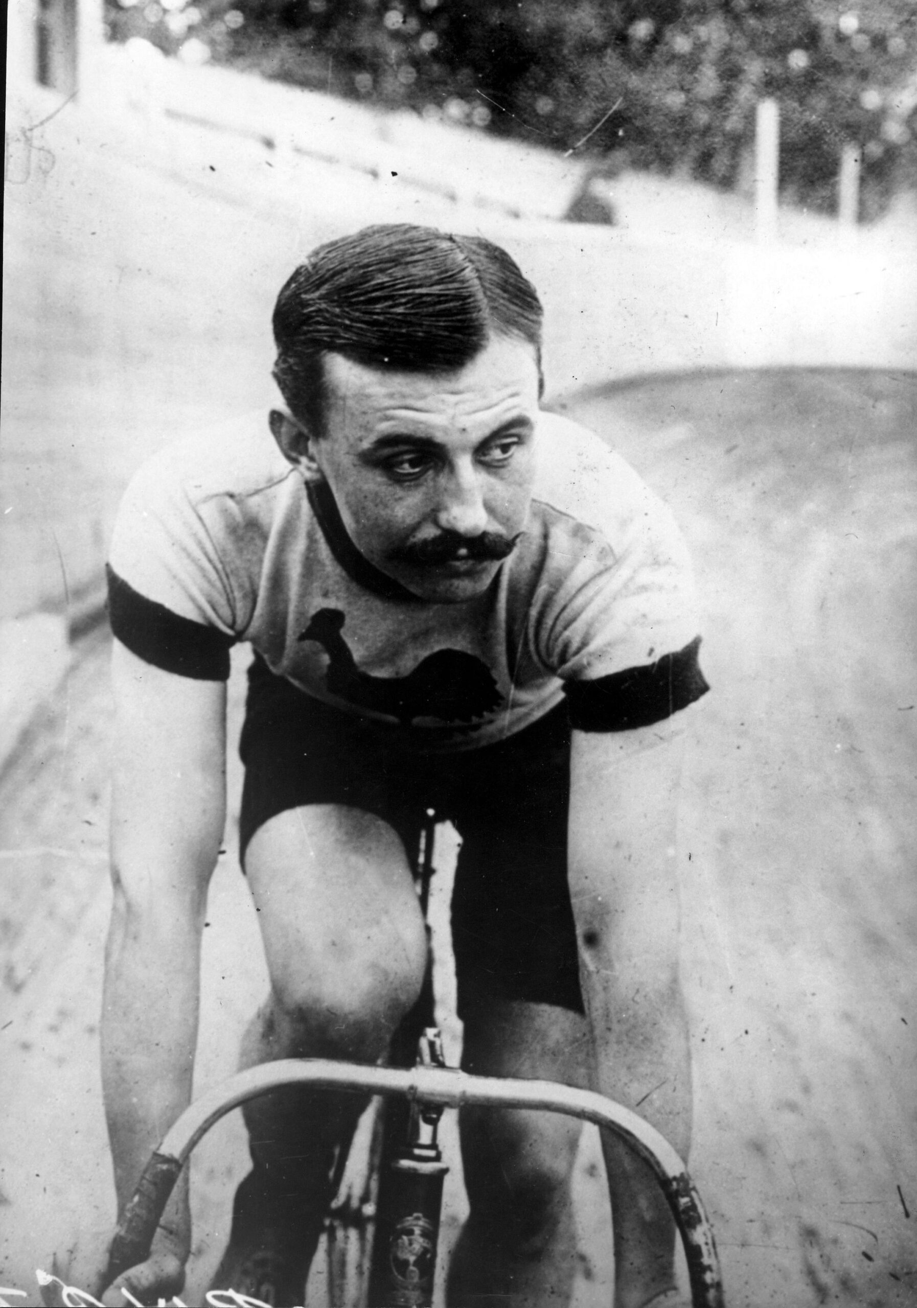 Omschrijving: De beroemde Franse wielrenner Lucien Petit-Breton, onder andere winnaar van de Tour de France (1907 en 1908) en de eerste Milaan-San Remo (1907), op een wielerbaan zonder plaats of jaartal. [Lucien Petit-Breton is een pseudoniem van Lucien Georges Mazan, 1882-1917]