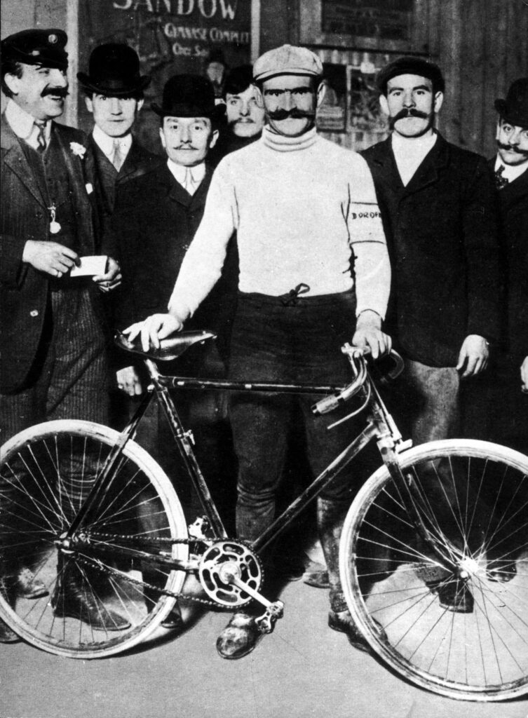 Omschrijving: Hippolyte Aucouturier, een van de kanshebbers in de Tour de France van 1903, die in de eerste rit zijn frame brak.